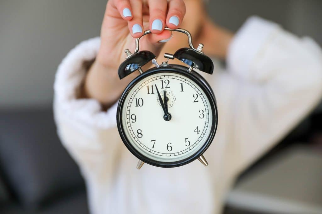 A person holding an alarm clock
